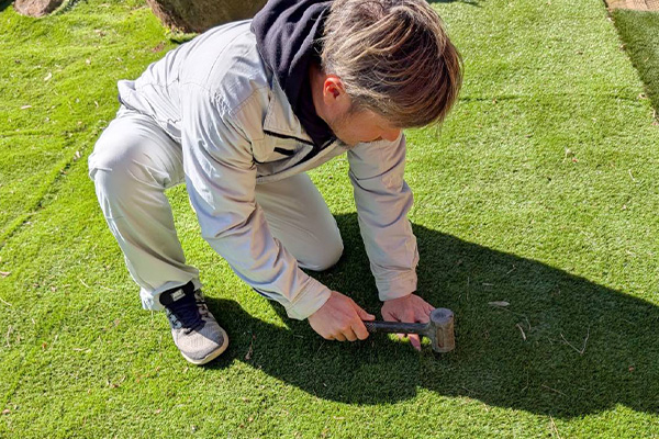 人工芝の施工をする社長のイメージ